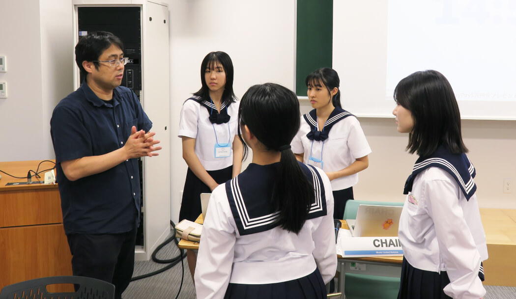 生徒と打ち合わせする関先生。みんなで世界を平和にしていこうという理念に賛同し模擬国連に取り組み、「生徒と一緒に世界平和作っていきたい」とのこと