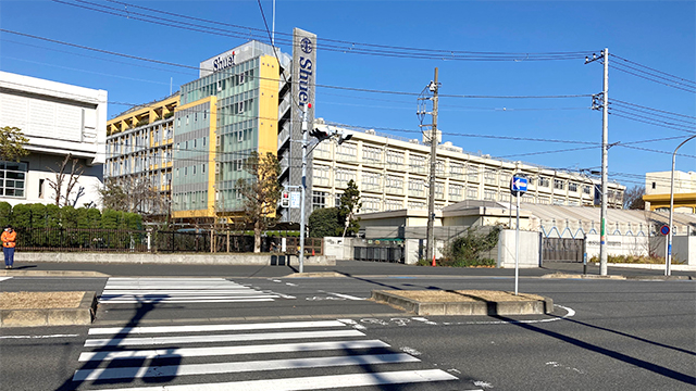 ⑤左手に「Shuei」の文字看板が掲げられた学校建物が見えてくる。横断歩道を渡る
