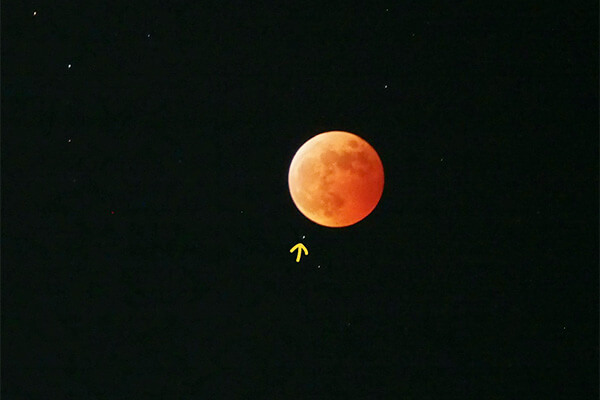 皆既中の月。実際はもっと赤黒い赤銅色ですが、天王星も写したいため明るめに撮影すると“ドラゴンボール”状態に。↑の先に青白い天王星