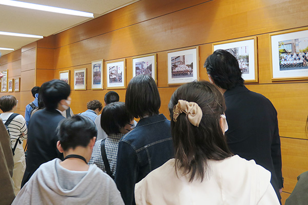 交換留学生との記念写真を見る見学者たち
